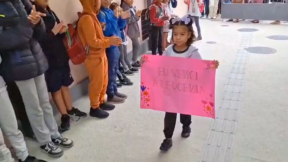Menina curada da leucemia é recebida com festa na escola