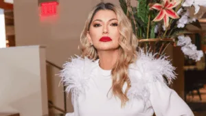 Antonia Fontenelle faz pose para foto usando roupa branca com plumas e batom vermelho