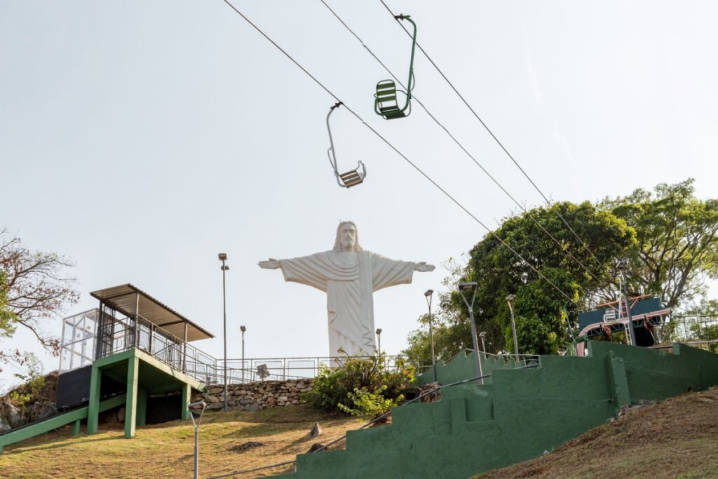 Imagem do Cristo Redentor em mirante na cidade de Serra Negra com teleféricos chegando