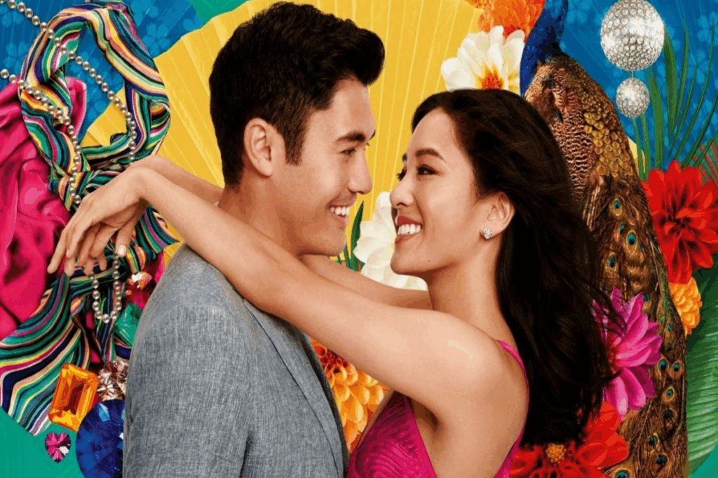 Casal abraçado olhando um para o outro em fundo colorido, o homem tem o cabelo curto e está usando um terno cinza e a mulher o cabelo longo, liso e está usando um vestido rosa