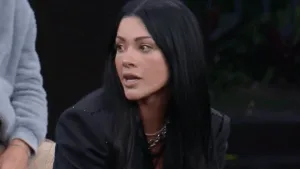 Rayane Figliuzzi de blazer preto olhando para a esquerda