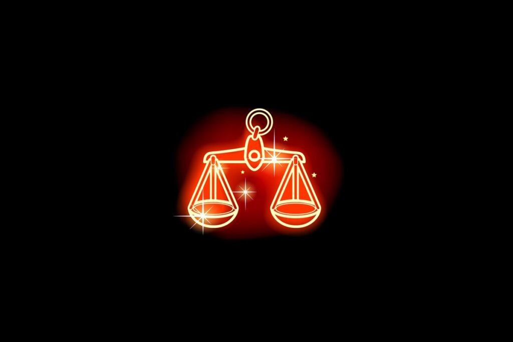 Ilustração em vermelho neon do signo de Libra em um fundo preto 