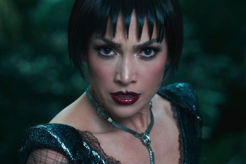 Jennifer Lopez de cabelo curto e preto, batom vermelho e colar 