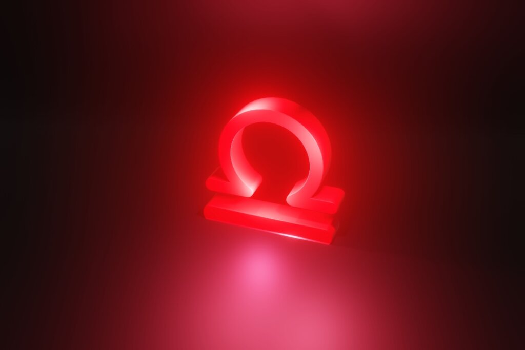 Ilustração em vermelho do símbolo do signo de Libra em fundo vermelho escuro