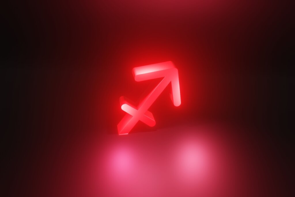 Ilustração em vermelho do símbolo do signo de Sagitário em fundo vermelho escuro