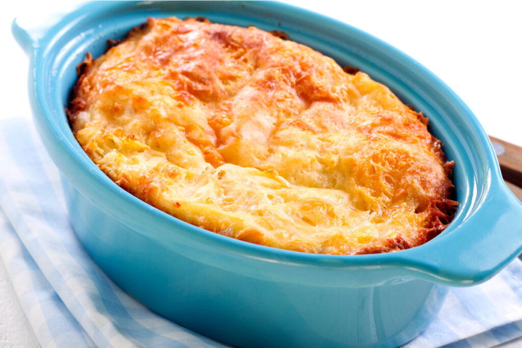 Suflê dentro de um recipiente azul sobre pano xadrez branco e azul