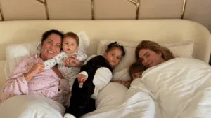 Margareth Serrão deitada com os netos e a filha, Virginia