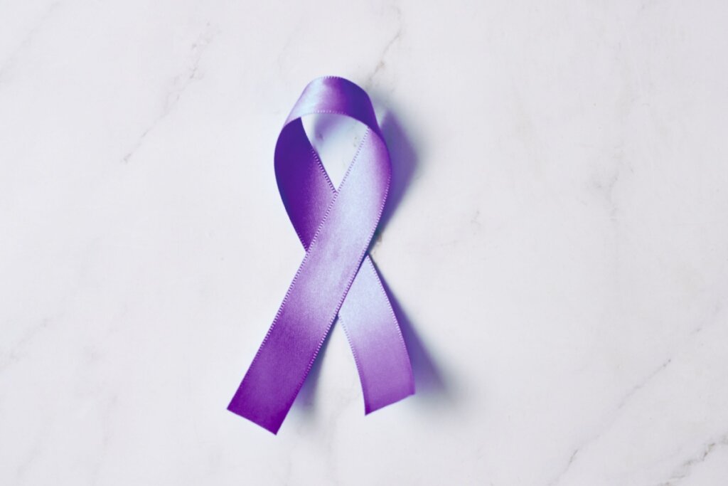 Laço roxo disposto em formato de fita de conscientização sobre a hanseníase